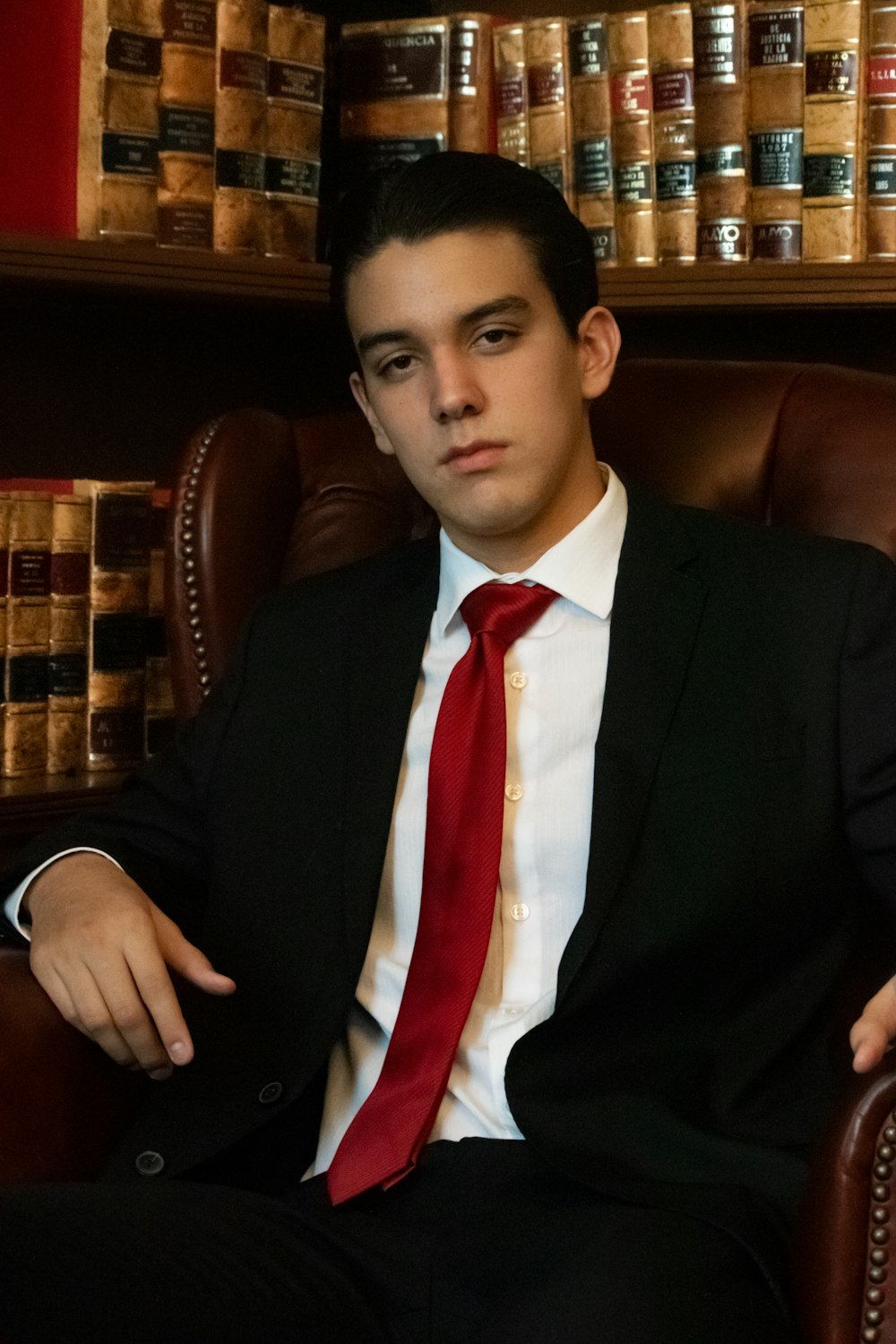 a man in a suit and tie sitting in a chair