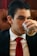 a man in a suit drinking from a glass