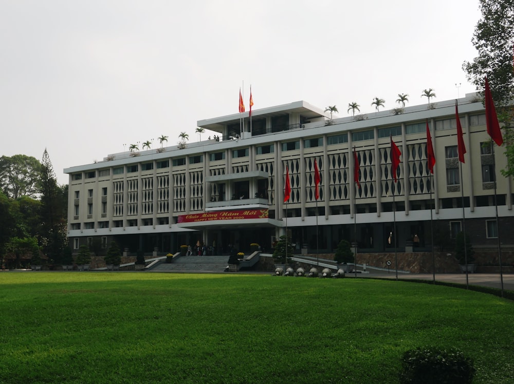 a large white building with red flags in front of it
