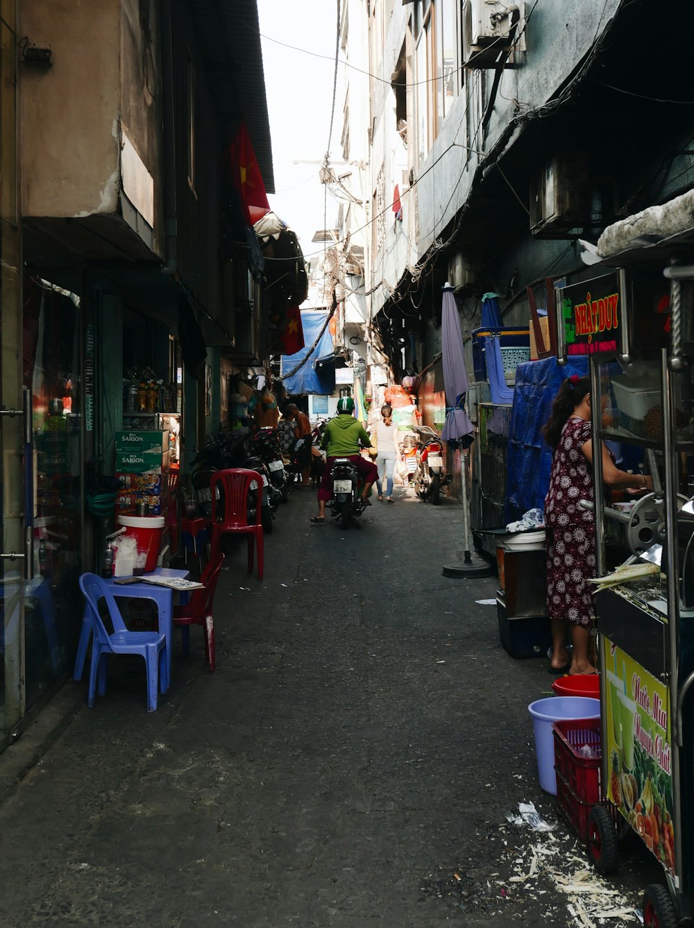 a narrow street with tables and chairs on both sides