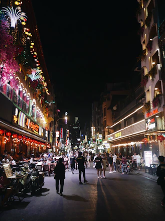 A lively night scene in Ho Chi Minh City with people enjoying dining and nightlife.