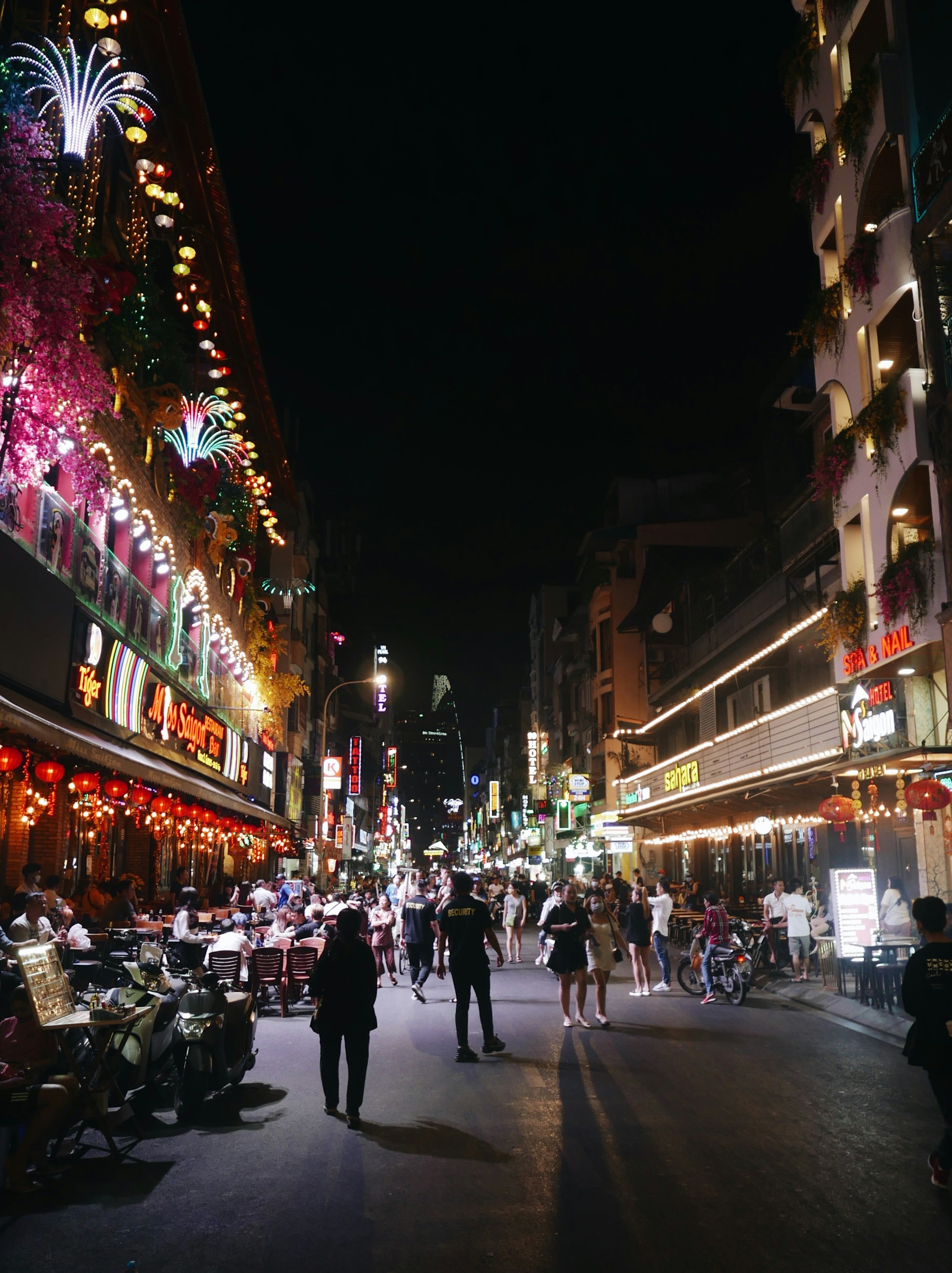 An energetic bachelorette crew exploring vibrant streets in Nashville, filled with colorful lights and lively atmosphere.