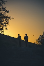 a couple of people that are walking down a hill