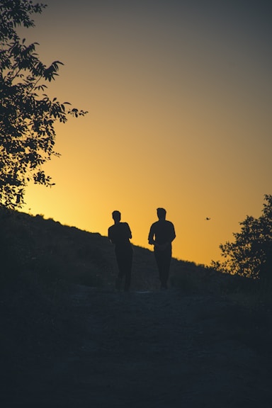 a couple of people that are walking down a hill