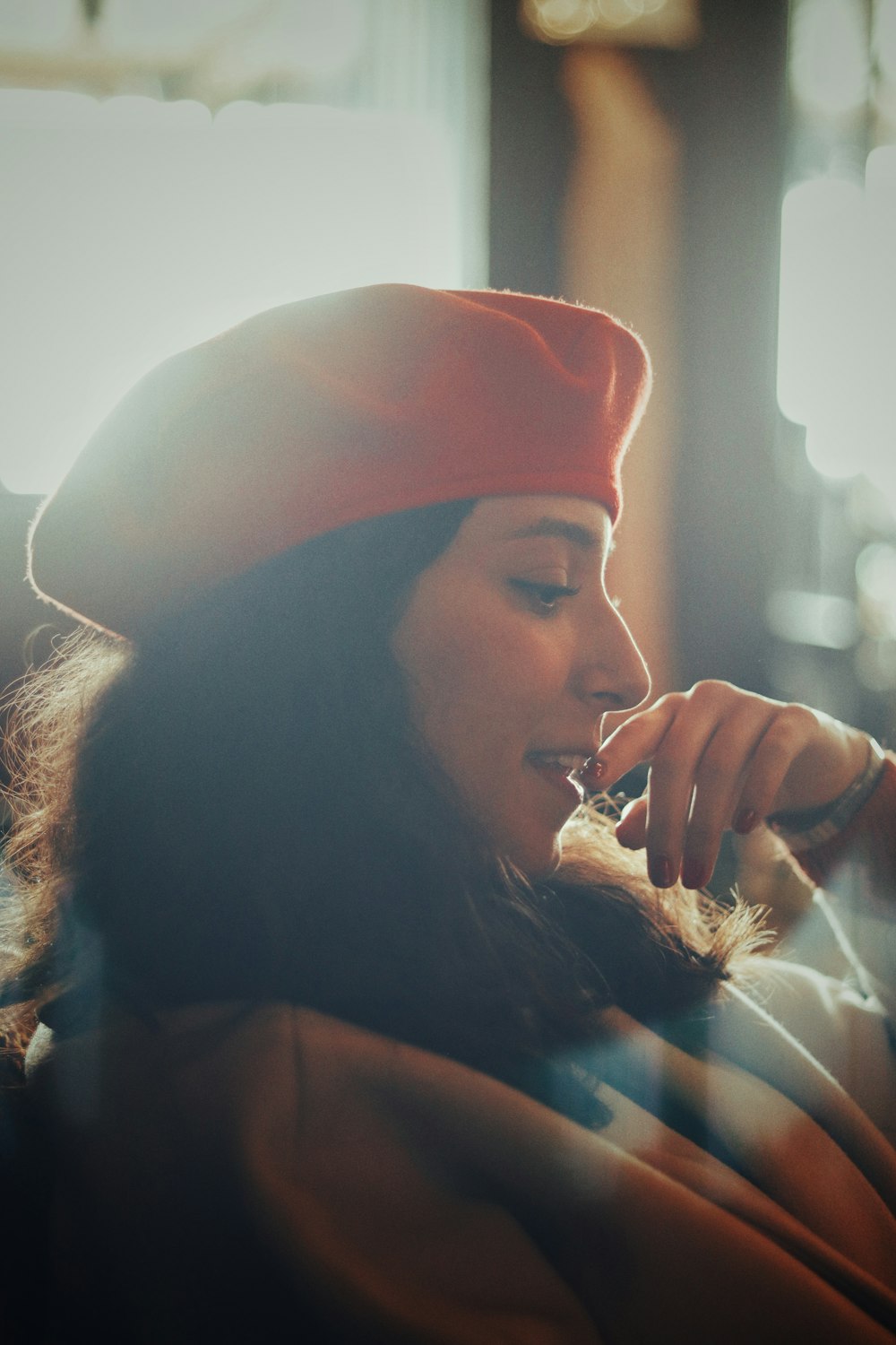 Eine Frau mit rotem Hut spricht auf einem Handy