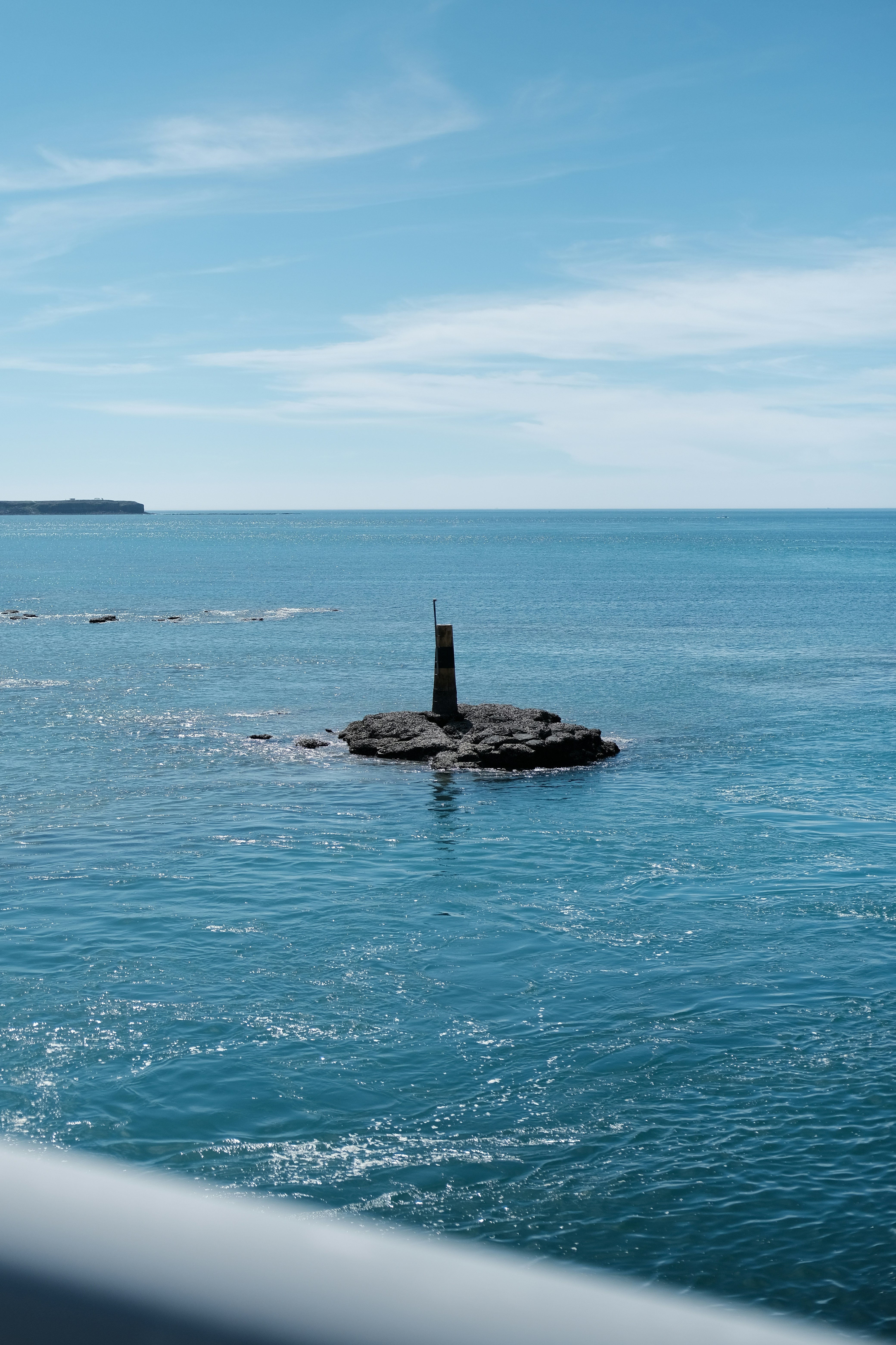 a small rock in the middle of a body of water