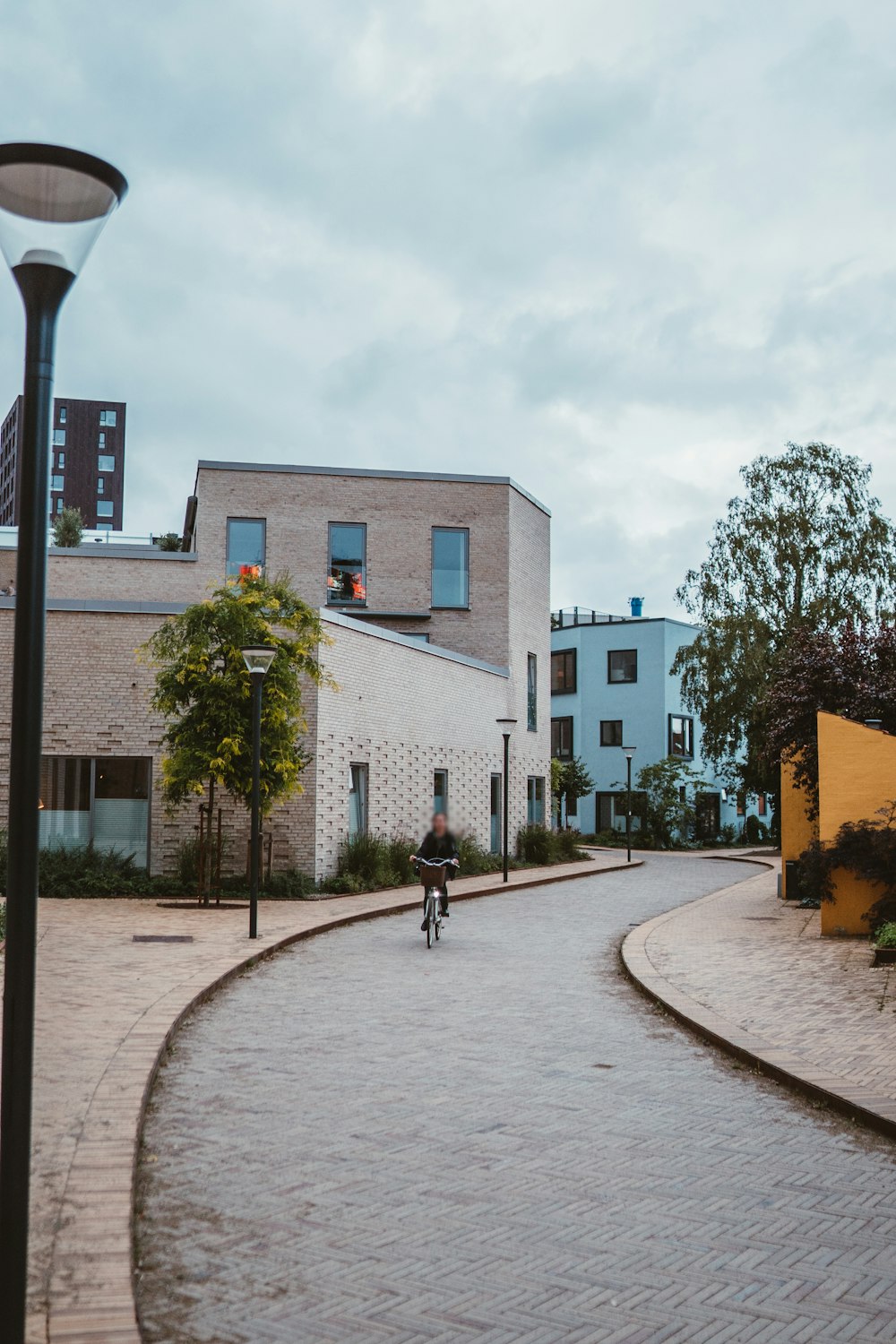 a person riding a bike down a cobblestone street