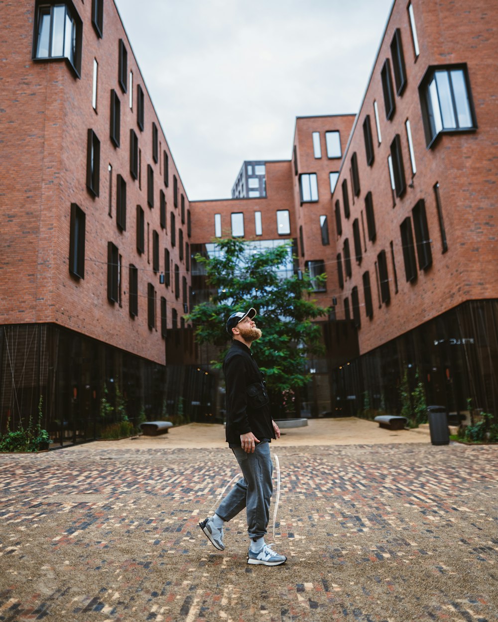 a man walking in front of a brick building