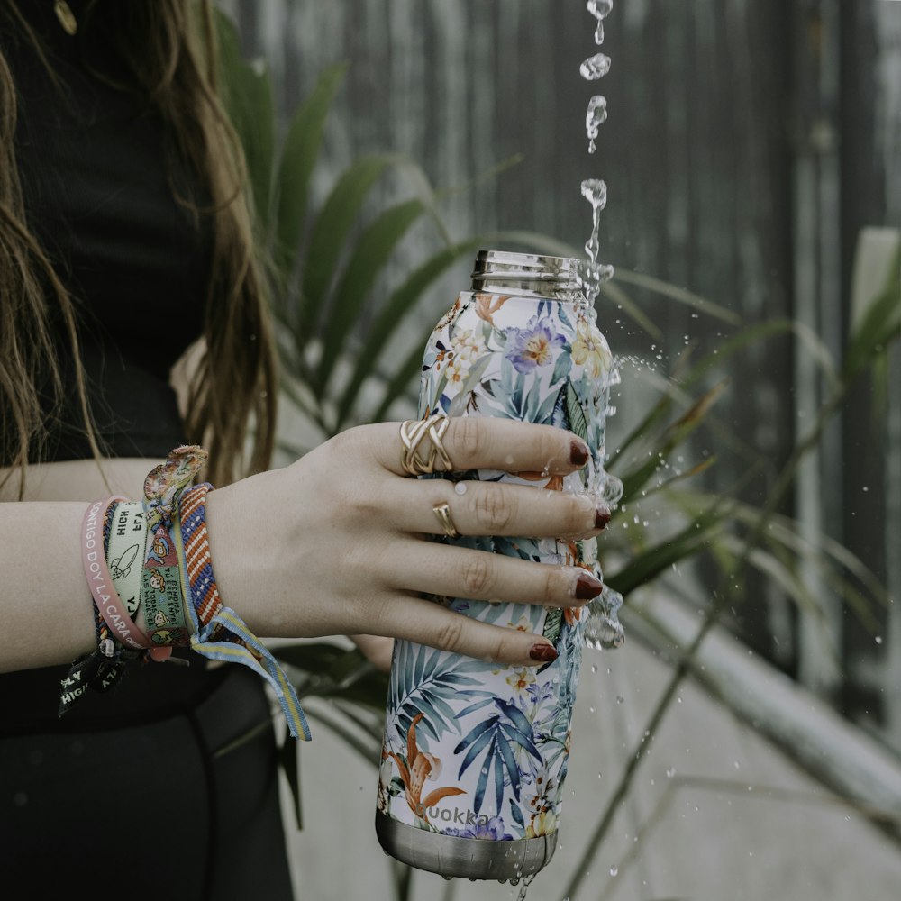 a woman holding a can of soda in her hand