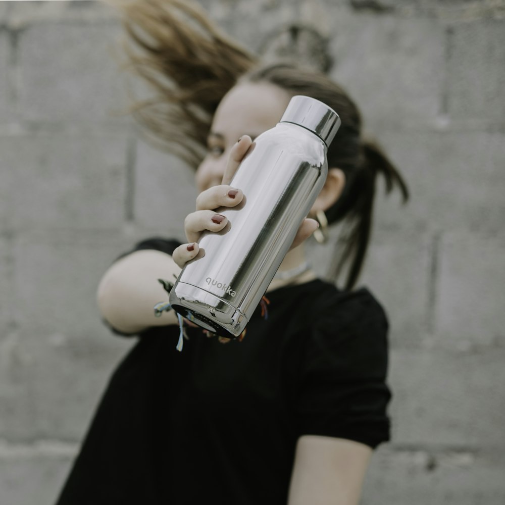 a woman holding a water bottle in her hands