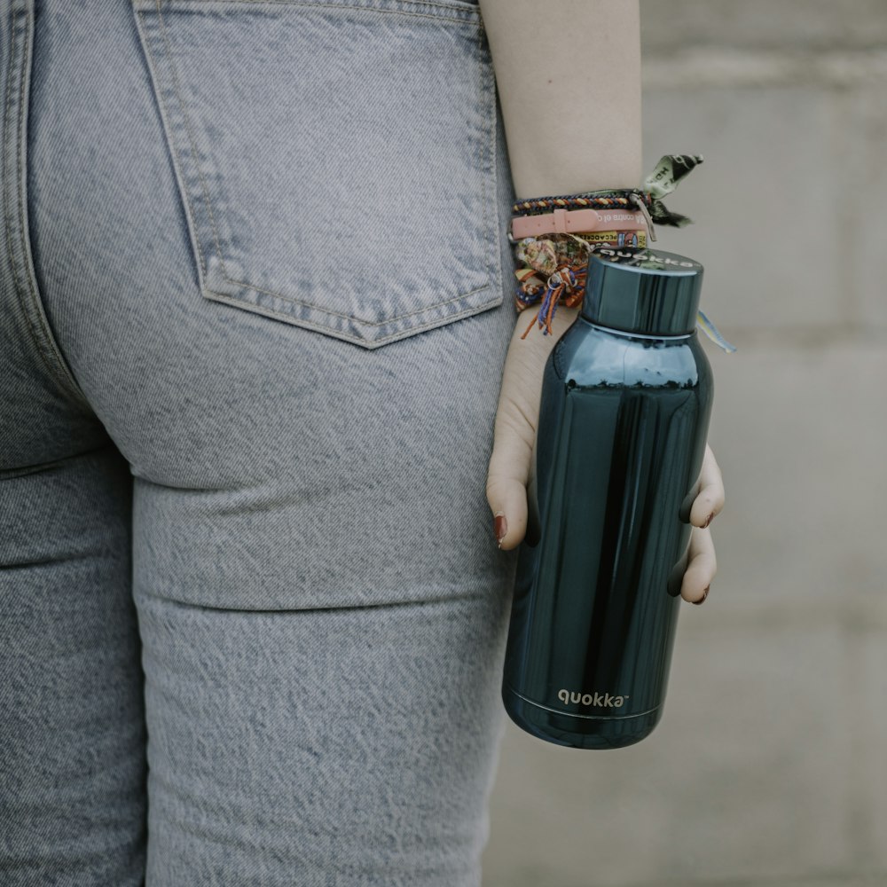 a person holding a water bottle in their hand