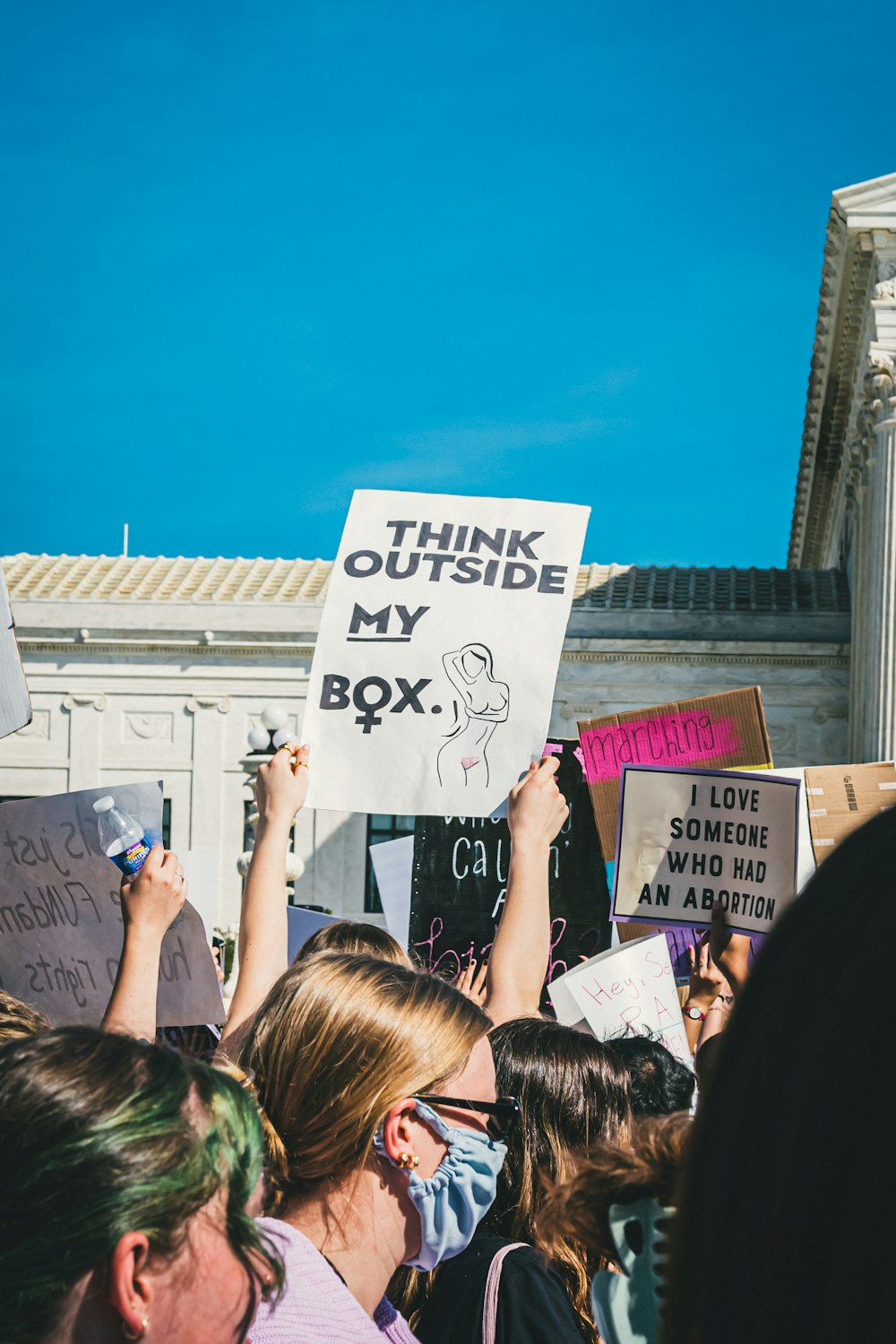 a group of people holding up signs in front of a building