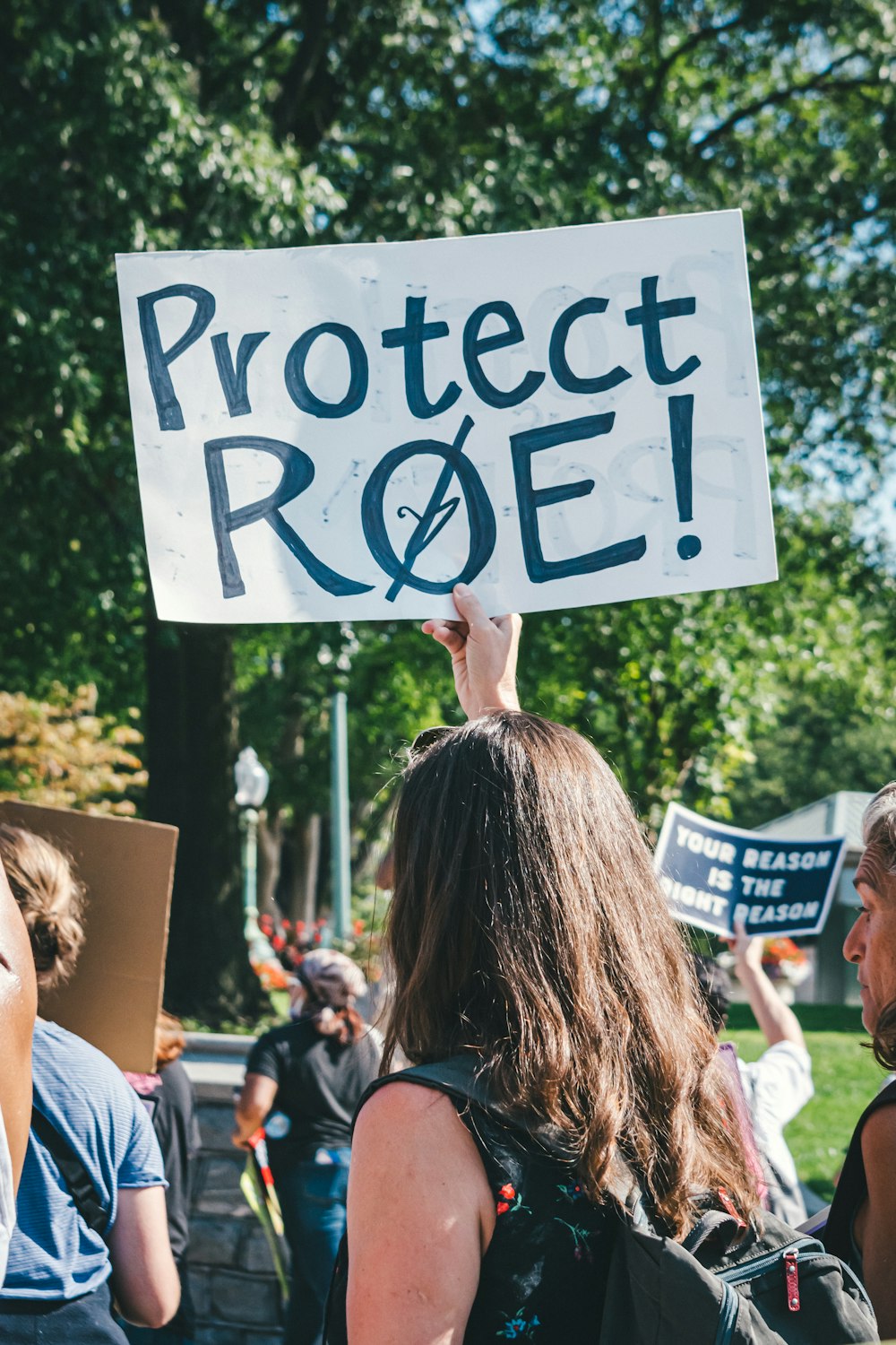 Eine Gruppe von Menschen hält ein Protestschild hoch