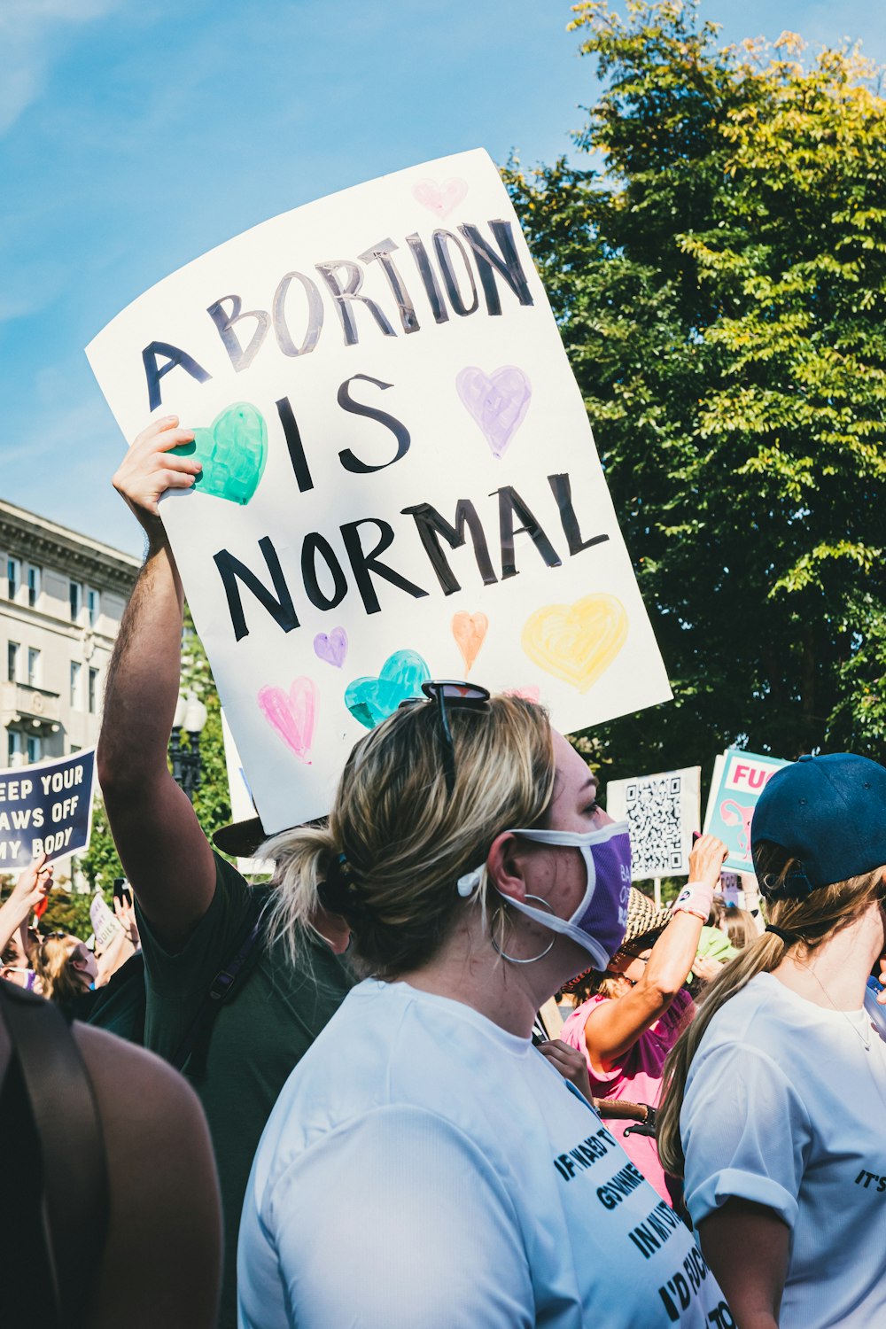 Eine Gruppe von Menschen, die ein Schild halten, das besagt, dass Abtreibung normal ist