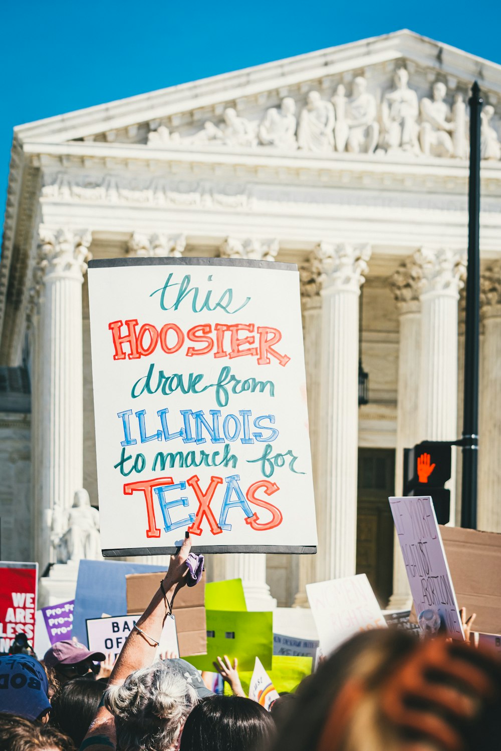 a group of people holding signs in front of a building