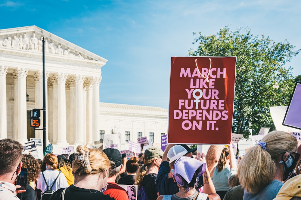 a group of people holding signs in front of a building