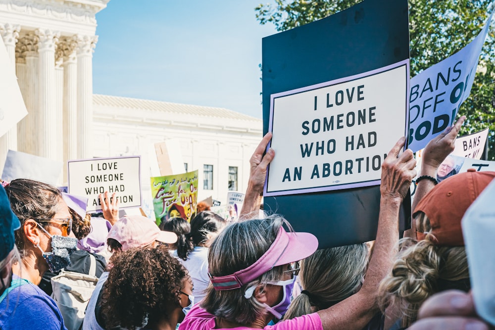 a group of people holding signs in front of a building