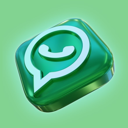 A three-dimensional glossy representation of a speech bubble icon with a telephone receiver inside, symbolizing a messaging app. The design features a smooth, transparent green surface with a glowing effect against a lighter green background.