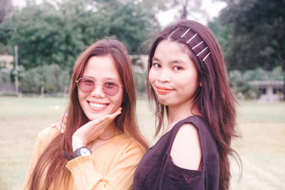 Happy customers wearing stylish outfits and natural makeup, smiling outdoors.