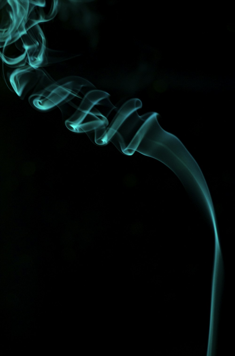 a close up of a green smoke on a black background