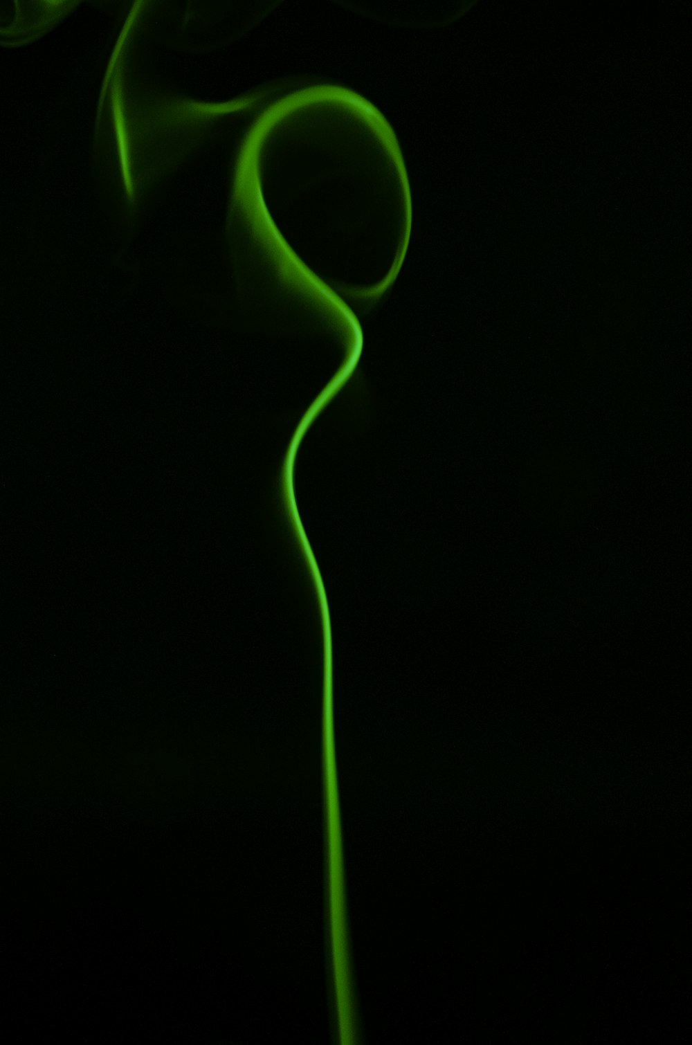 a black background with a green light in the middle of it