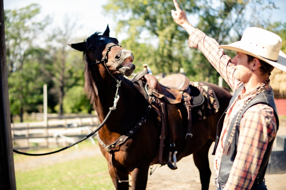 a man standing next to a brown horse