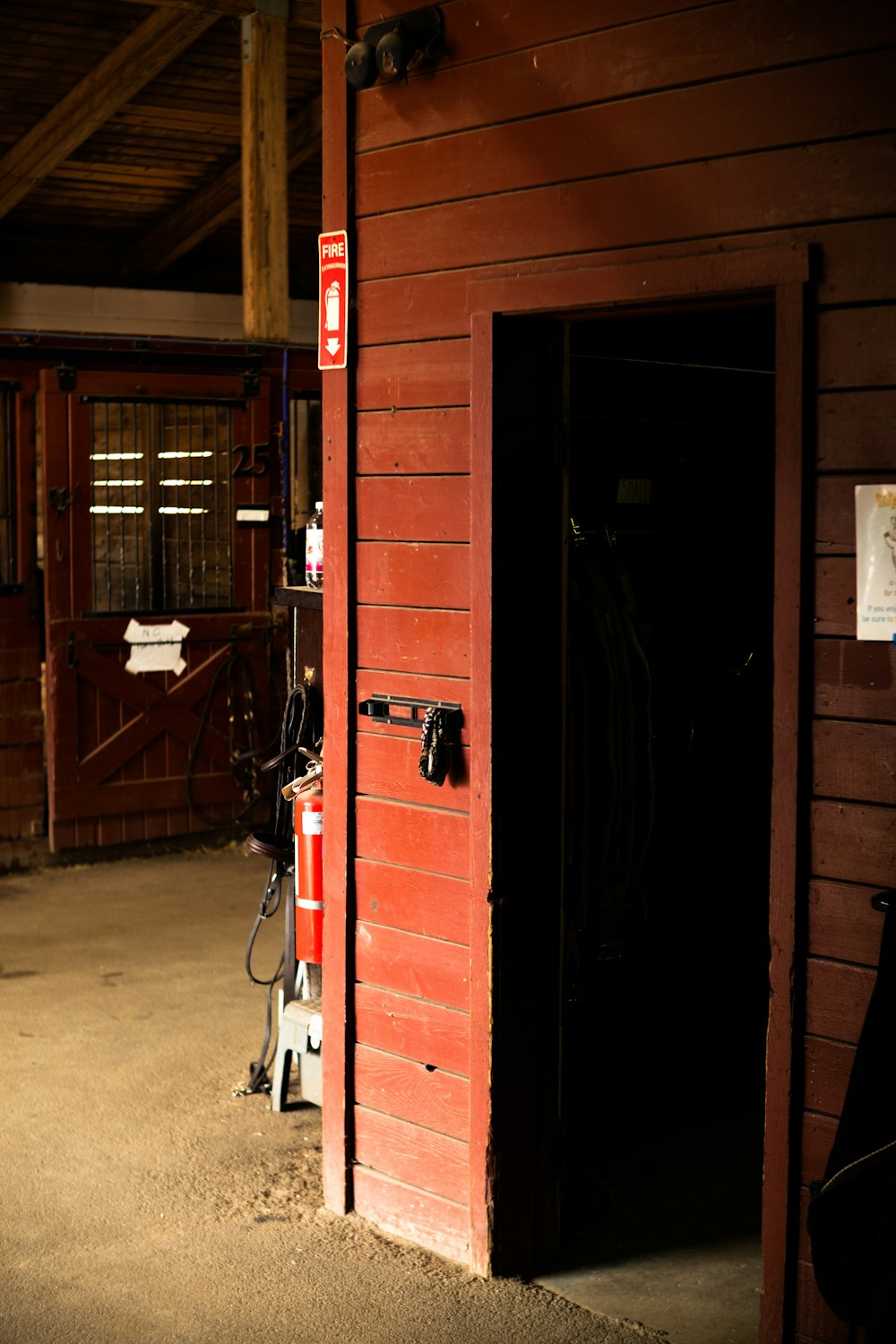 a red barn with a black door and a red light