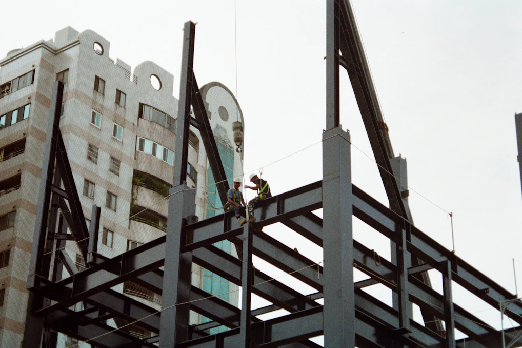 a couple of men working on a tall building