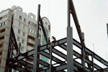 a couple of men working on a tall building