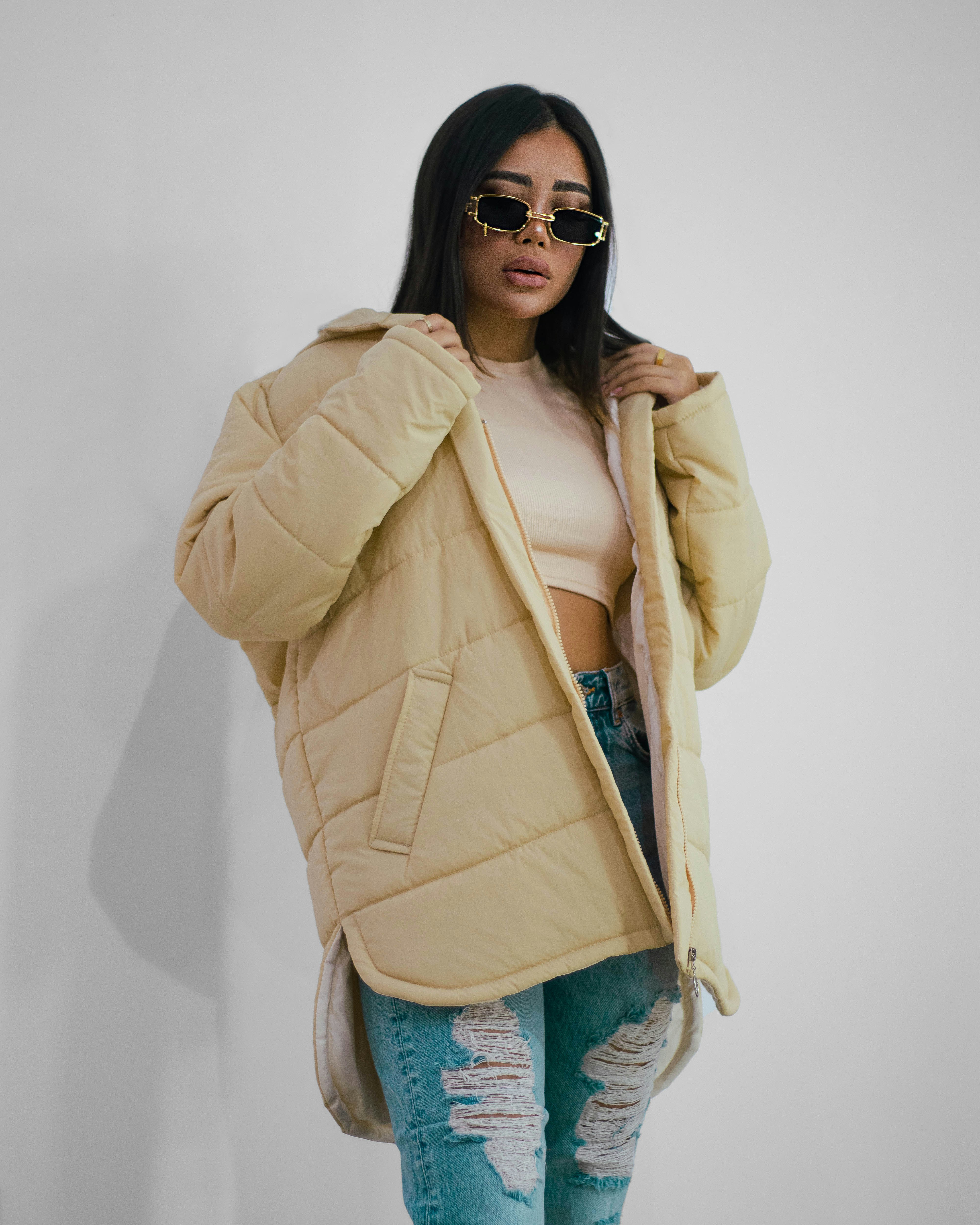 a woman in ripped jeans and a puffy jacket