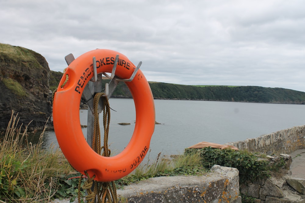 an orange life preserver sitting on the side of a cliff