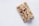 Two granola bars made from oats, nuts, and dried fruits are placed on a light gray background. The texture of the bars appears crunchy with visible almonds and cranberries.