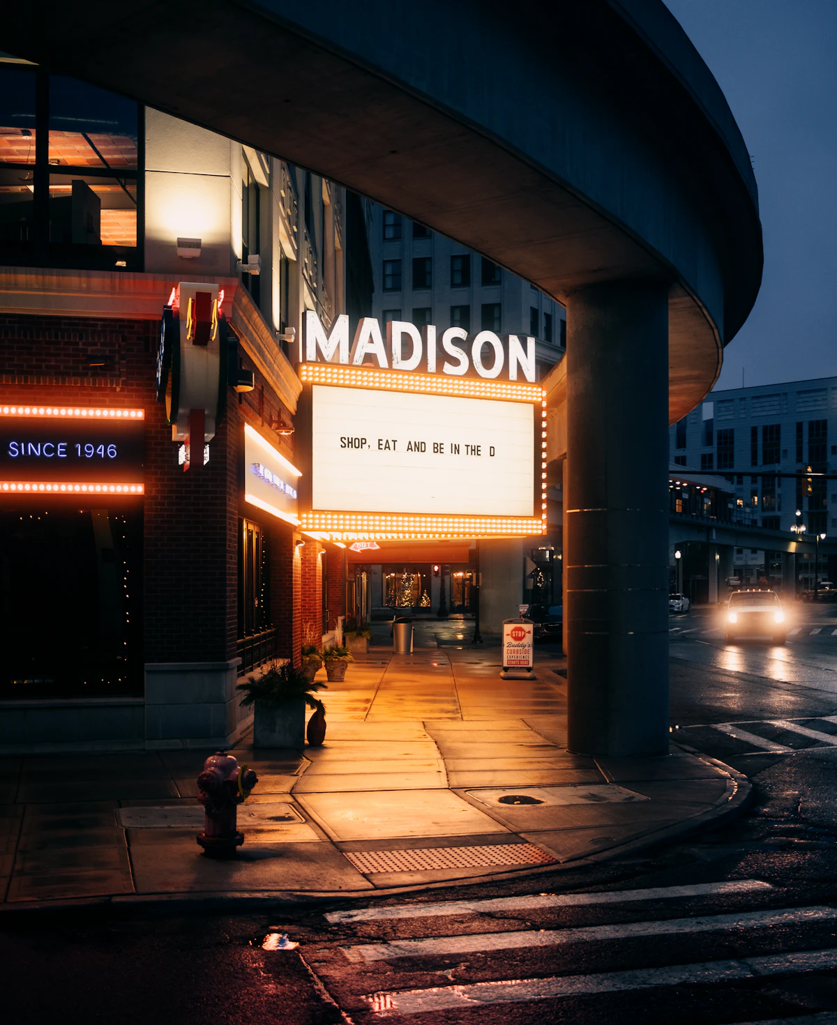 Illuminated theater marquee on a Detroit street at night