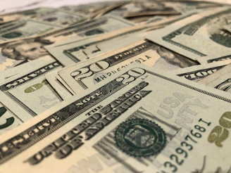 A vibrant close-up of US dollar bills fanned out on a wooden table.