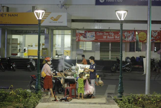 A Vietnam Post delivery worker handing a package to a smiling customer at a local post office.