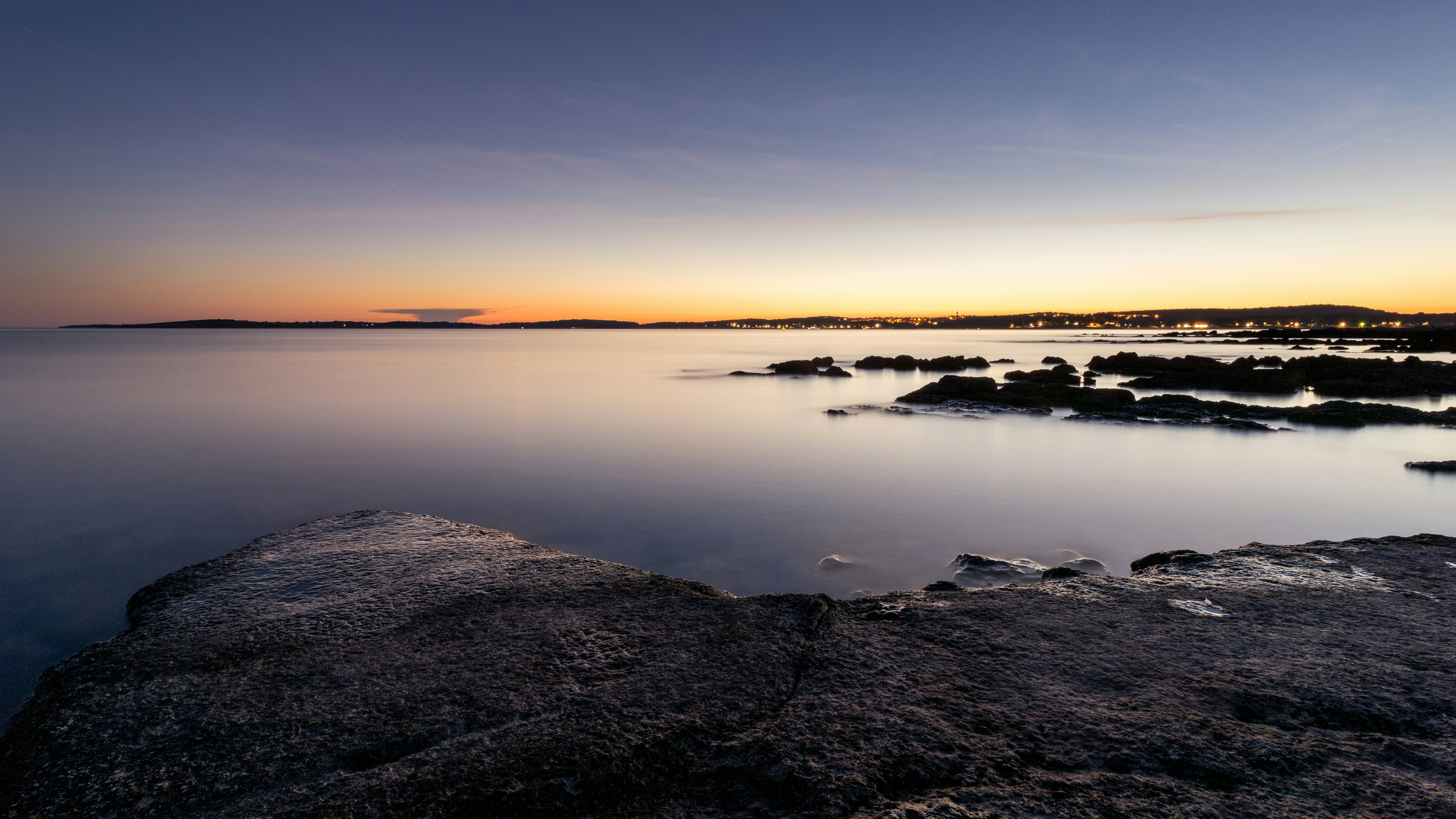 a body of water with rocks in the foreground