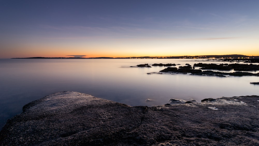 a body of water with rocks in the foreground