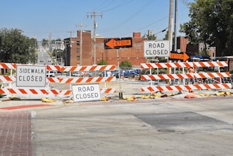 a road closed sign sitting on the side of a road