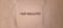 The image features a textured beige wall with a square area in the center that has the word 'PHOTOGRAPHY' stenciled in black, capital letters.