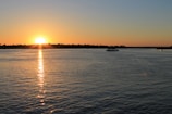 the sun is setting over a body of water