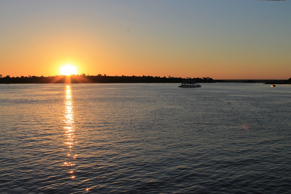 the sun is setting over a body of water