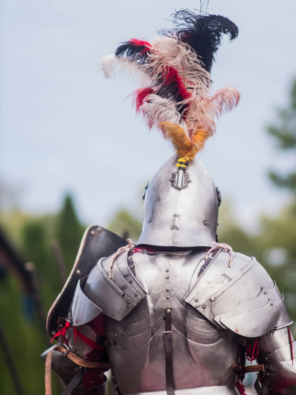 a man in a suit of armor with feathers on his head