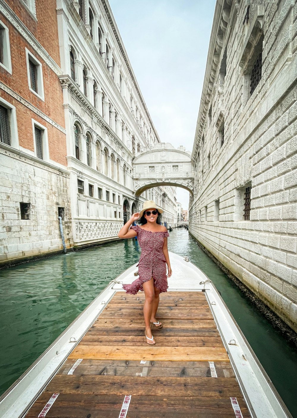 a woman in a dress is walking on a boat