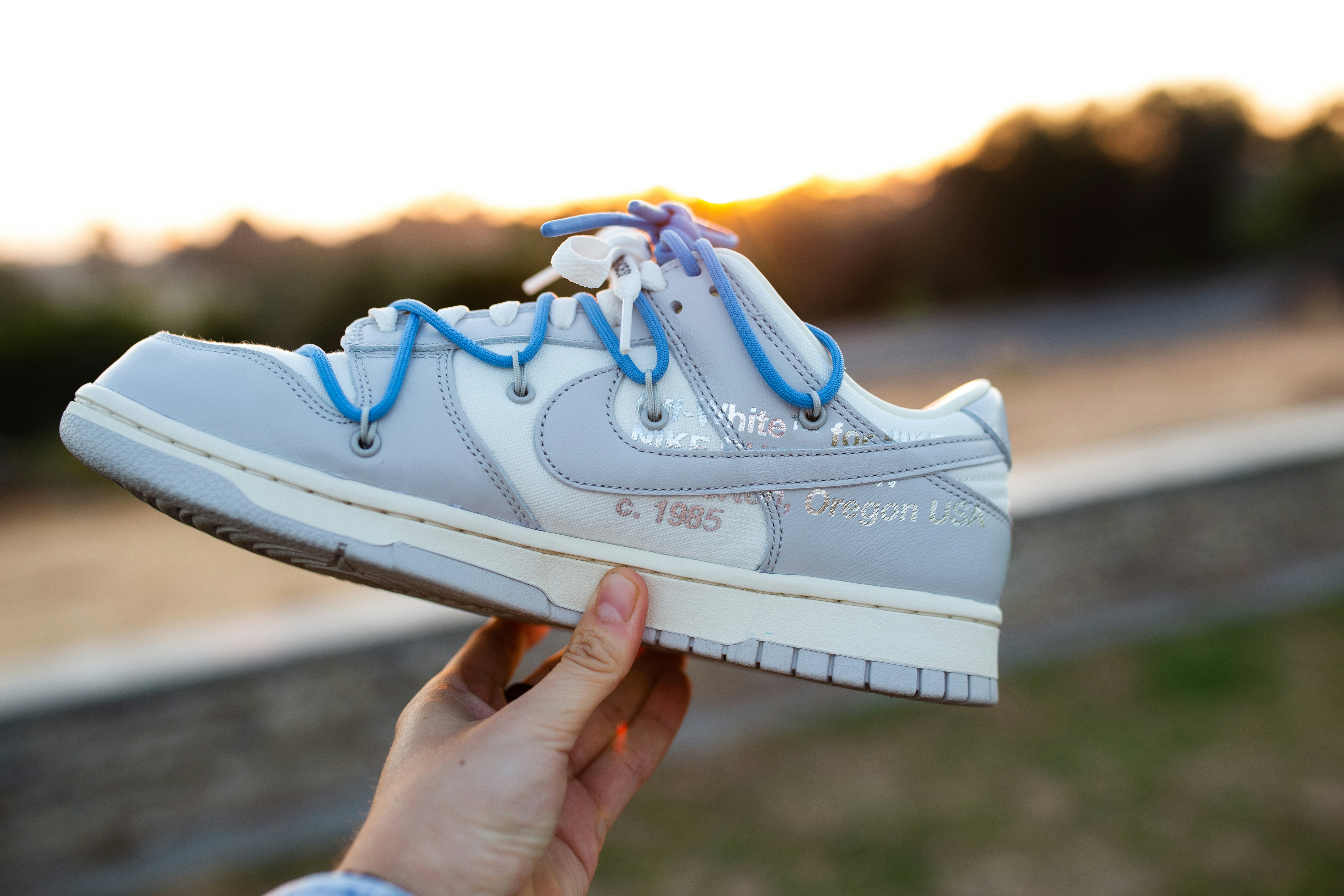 a person holding up a pair of shoes