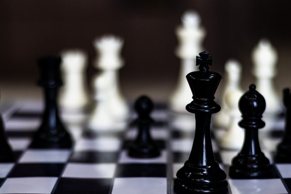 a close up of a chess board with black and white pieces