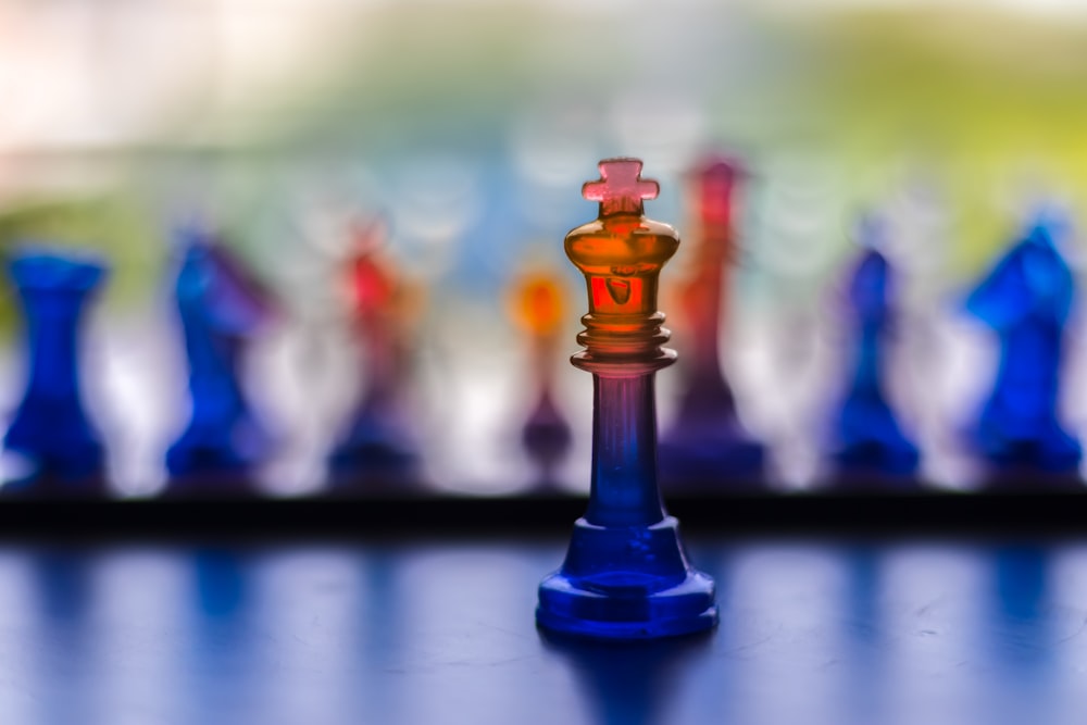 a glass chess set with a blurry background