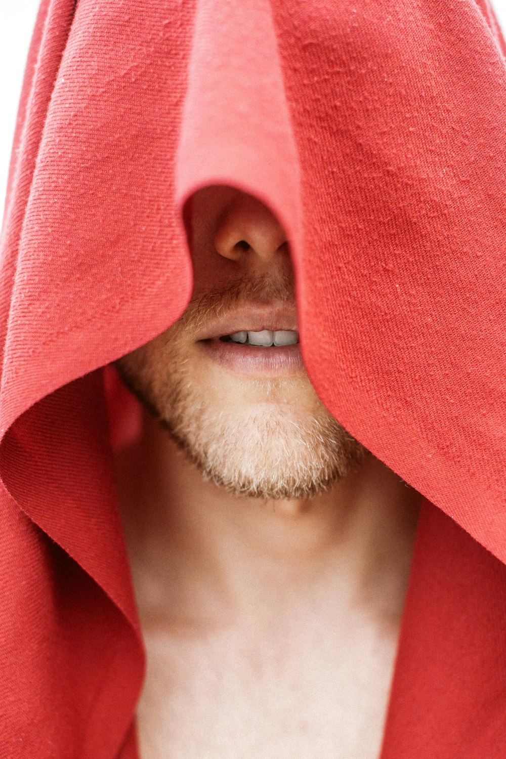 a man wearing a red towel over his face