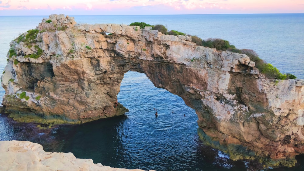 a person swimming in a body of water under a bridge