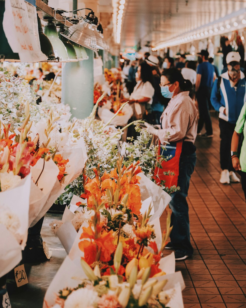 a group of people standing around a flower shop