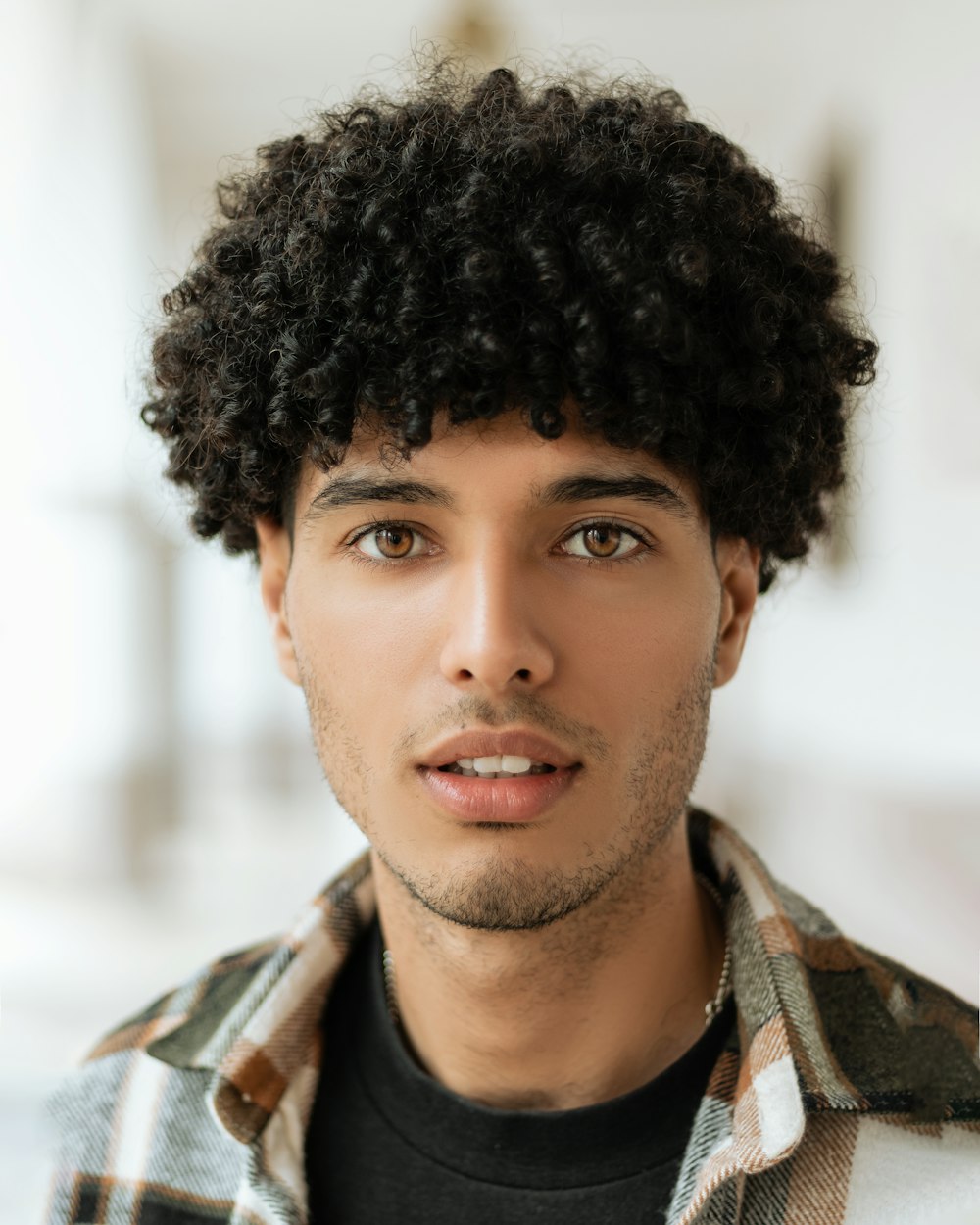 a close up of a person wearing a plaid shirt